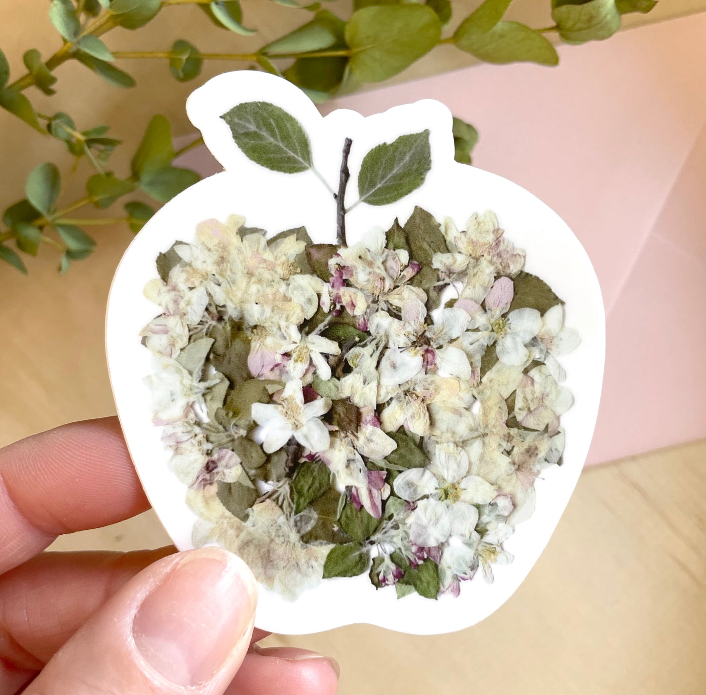 sticker of floral apple made from real apple blossoms and arranged in the shape of an apple.