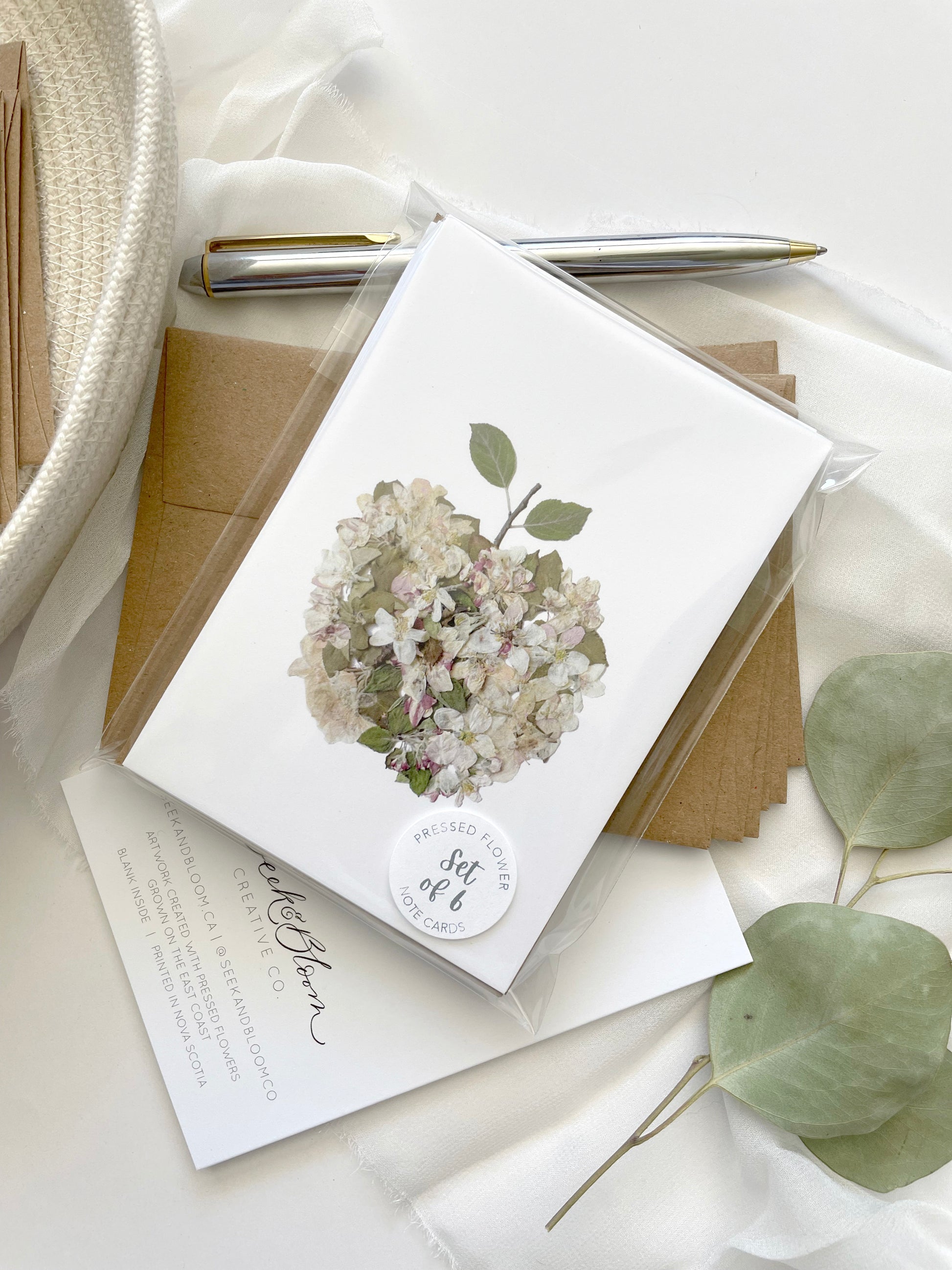 apple artwork made from white pink and green apple blossom flowers and leaves