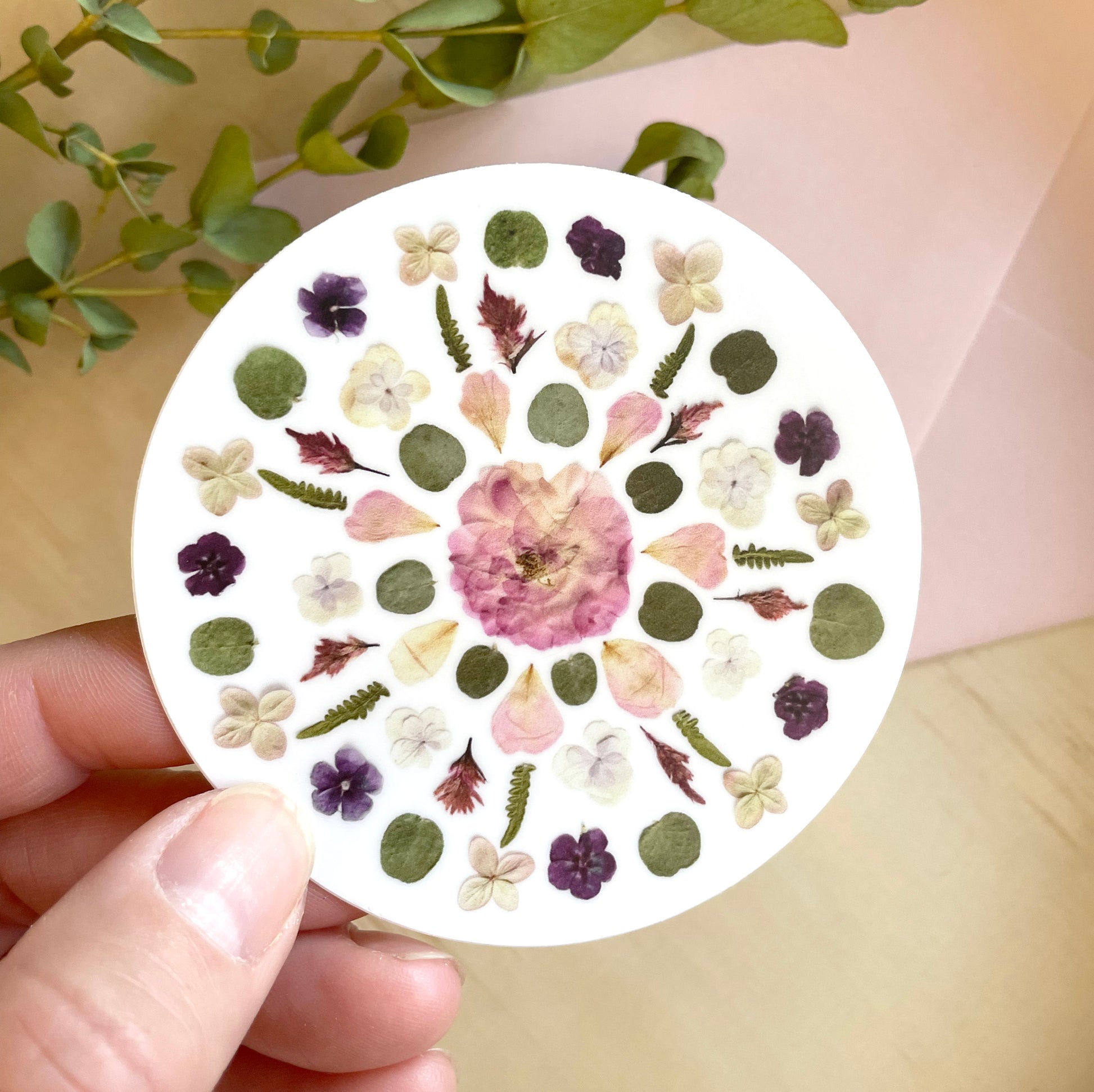 circle sticker mandala design made with pink and purple pressed flowers.