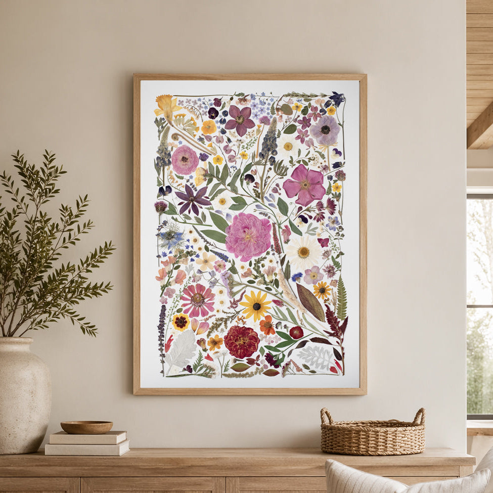 Floral artwork in a wooden frame on a wall above a wooden cabinet in a living room.