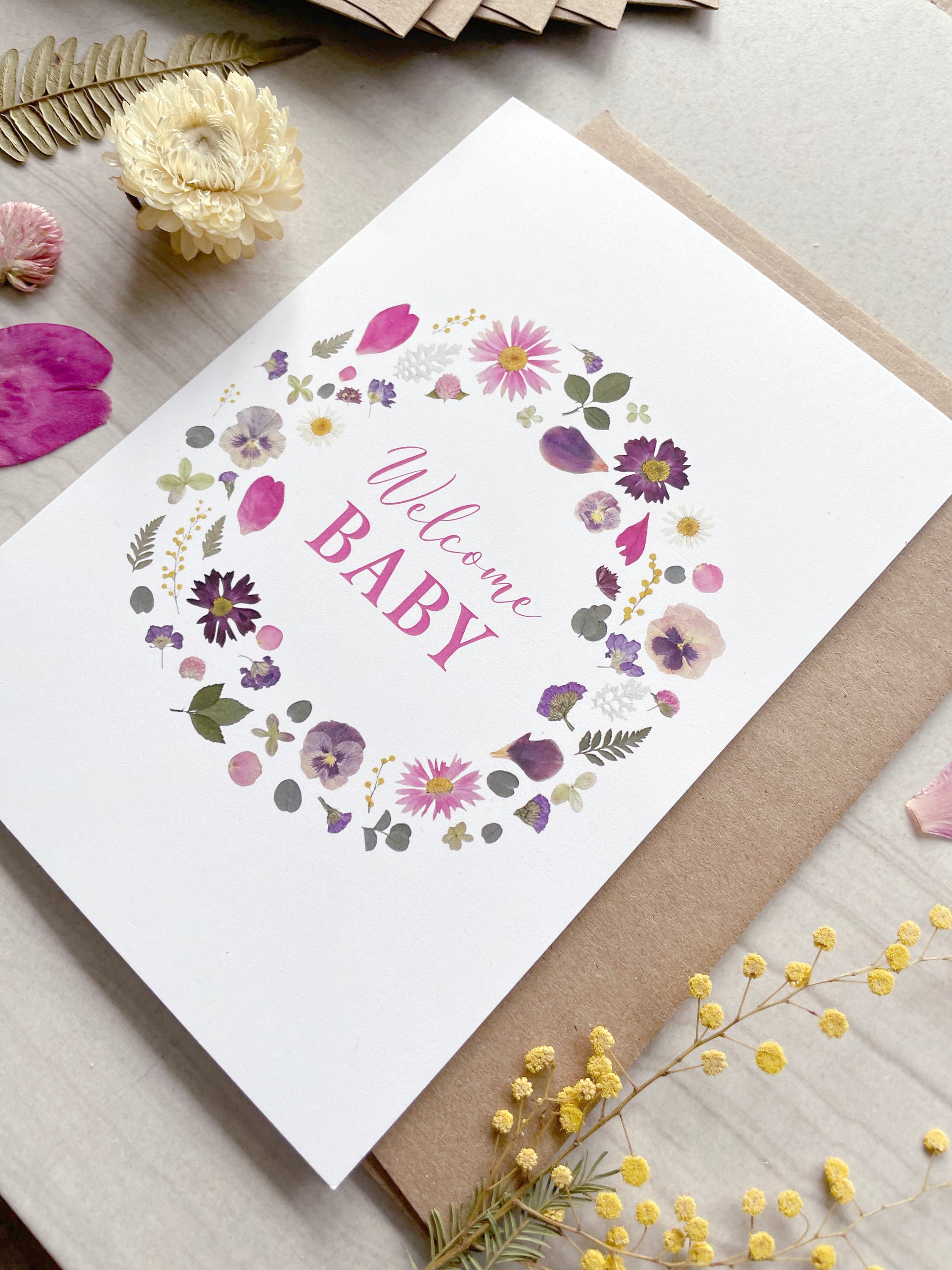 welcome baby card with pink and purple pressed flowers
