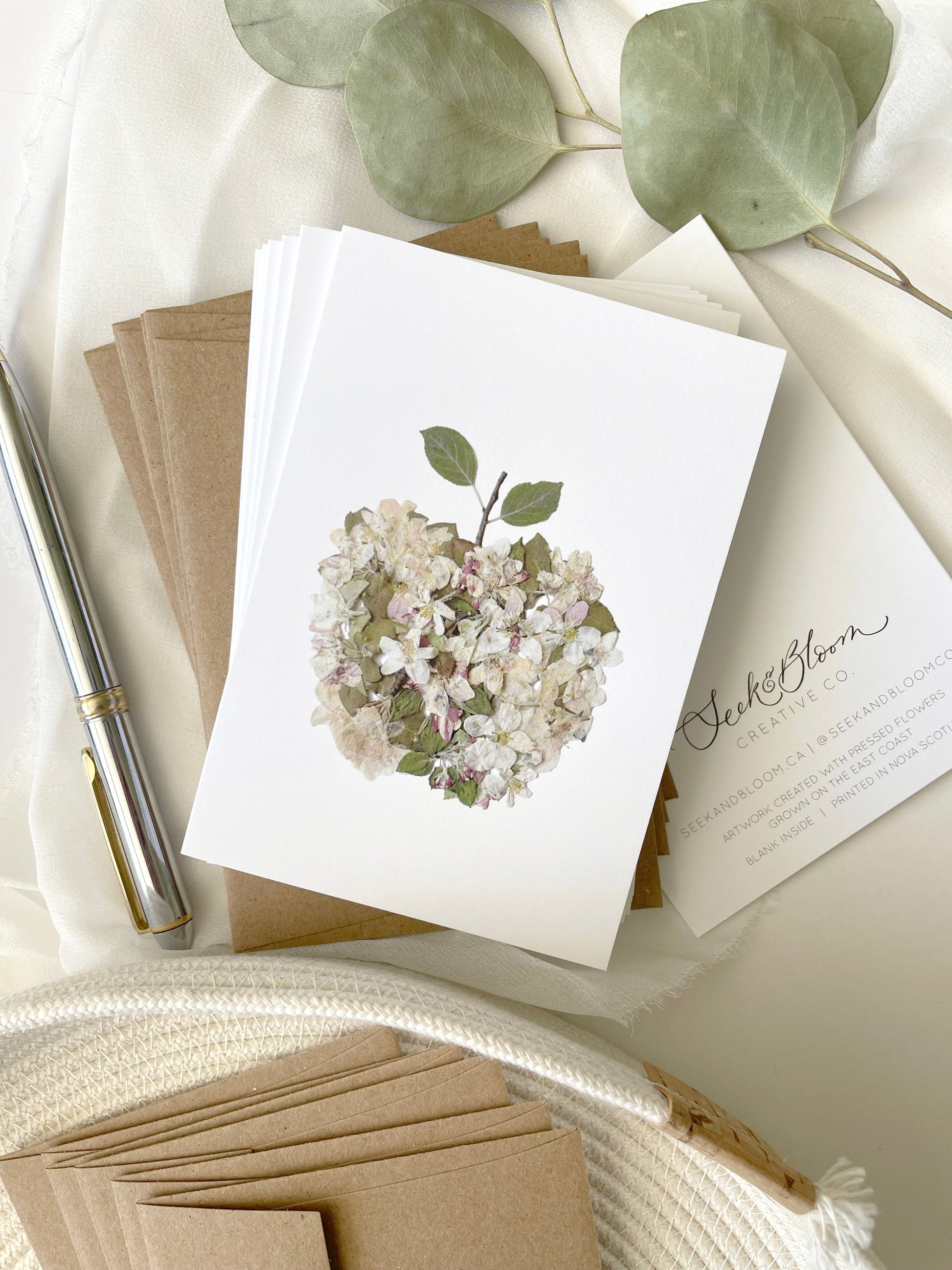 apple artwork made from white pink and green apple blossom flowers and leaves 