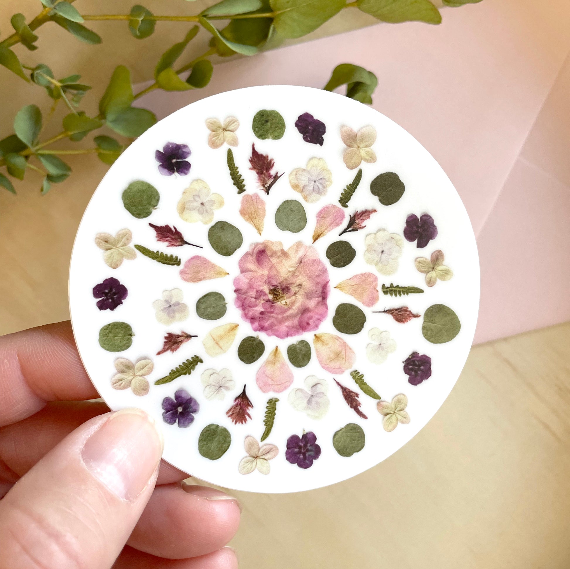 circle sticker mandala design made with pink and purple pressed flowers. 