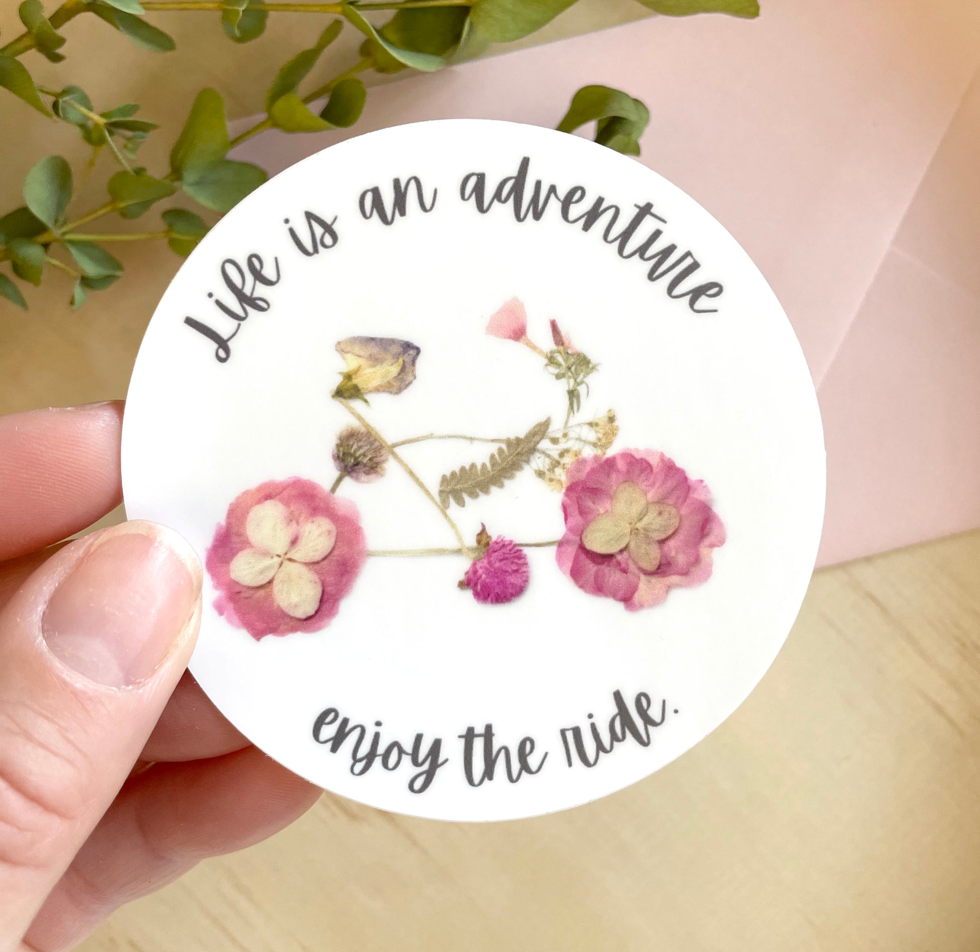 sticker of pink floral bike made from dried flowers, quote life is an adventure enjoy the ride. 